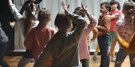 Powiększ grafikę: Grupa uczniów uczestniczących w zajęciach tanecznych podczas warsztatów.