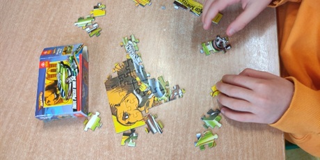 Powiększ grafikę: Uczeń podczas układania puzzli